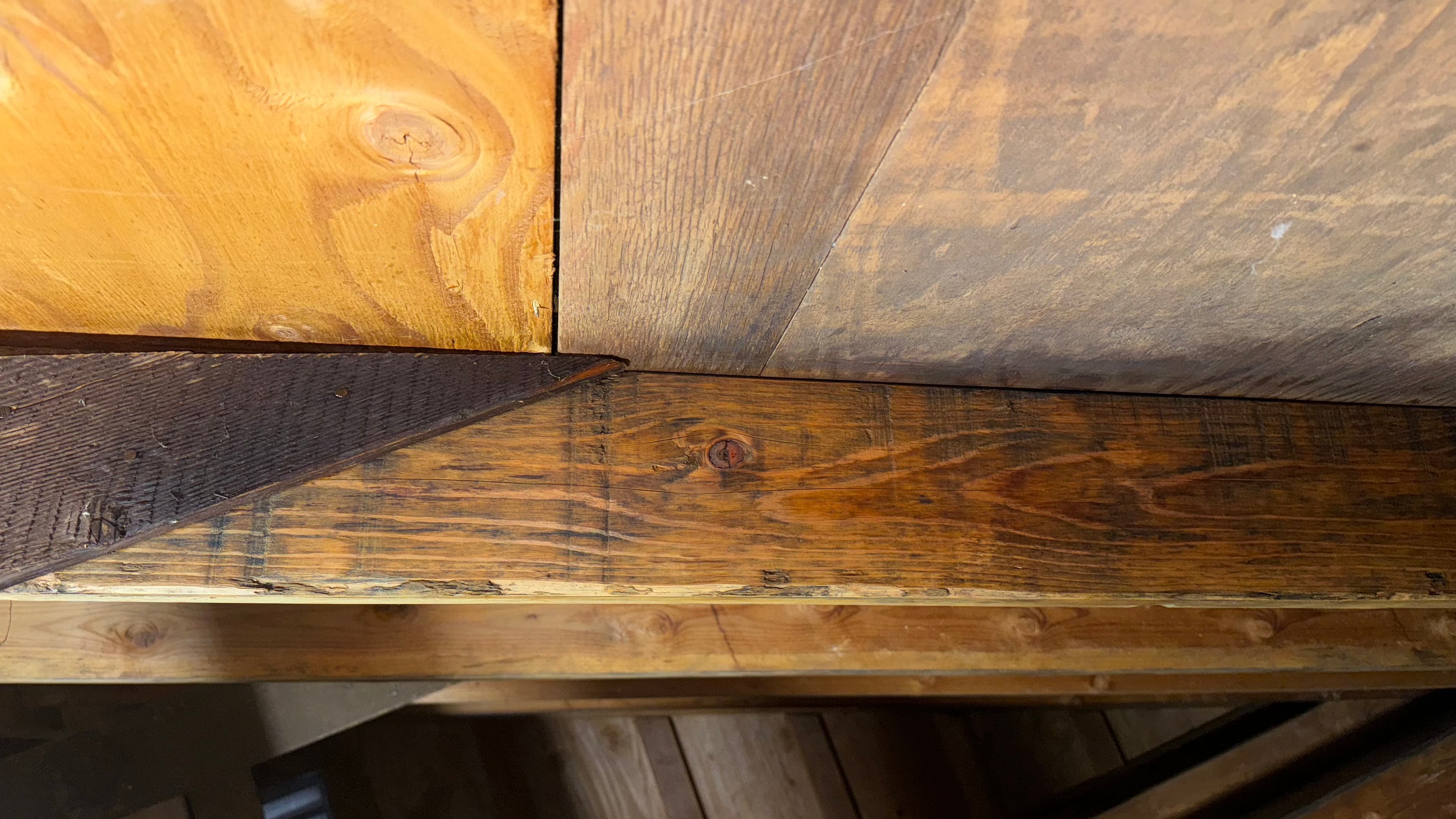 After: Attic rafter with dark mold staining removed — natural wood grain restored beneath roof sheathing