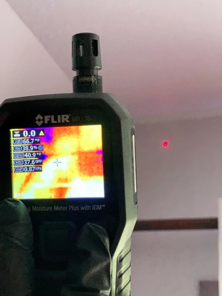 FLIR thermal imaging camera scanning a wall for hidden moisture during inspection